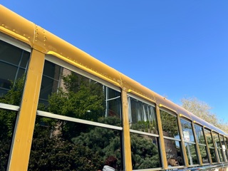 A yellow school bus on a clear morning, symbolizing the district-wide bell schedule debate.